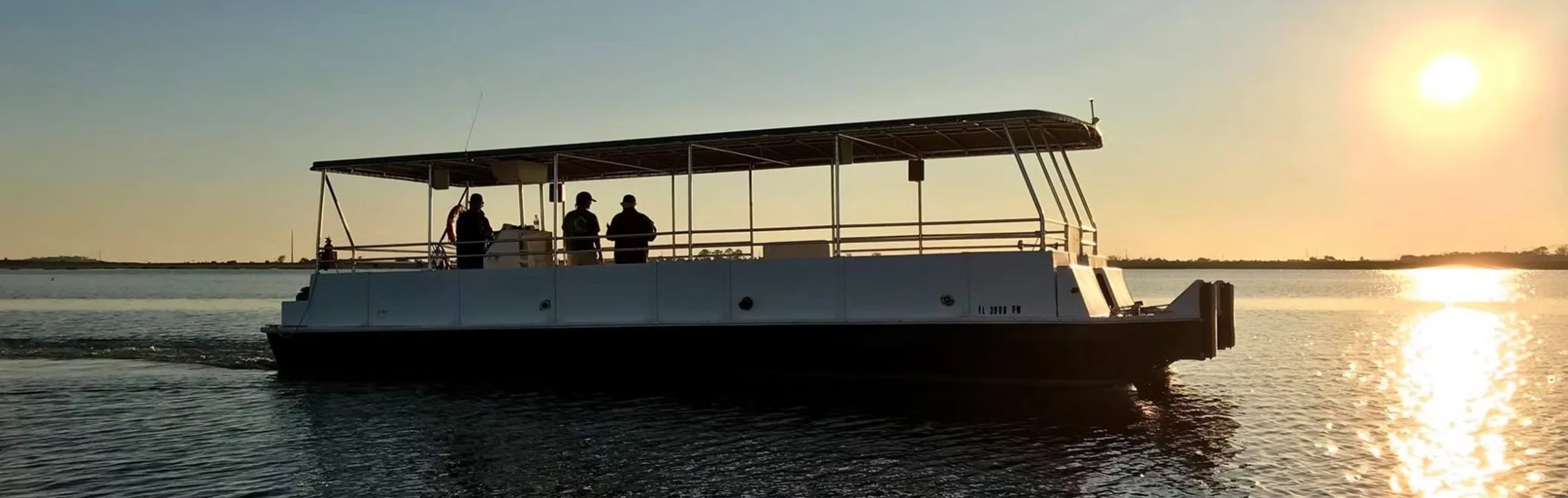 The Lighthouse Dolphin Tours boat at golden hour on the water near St. Simons Island