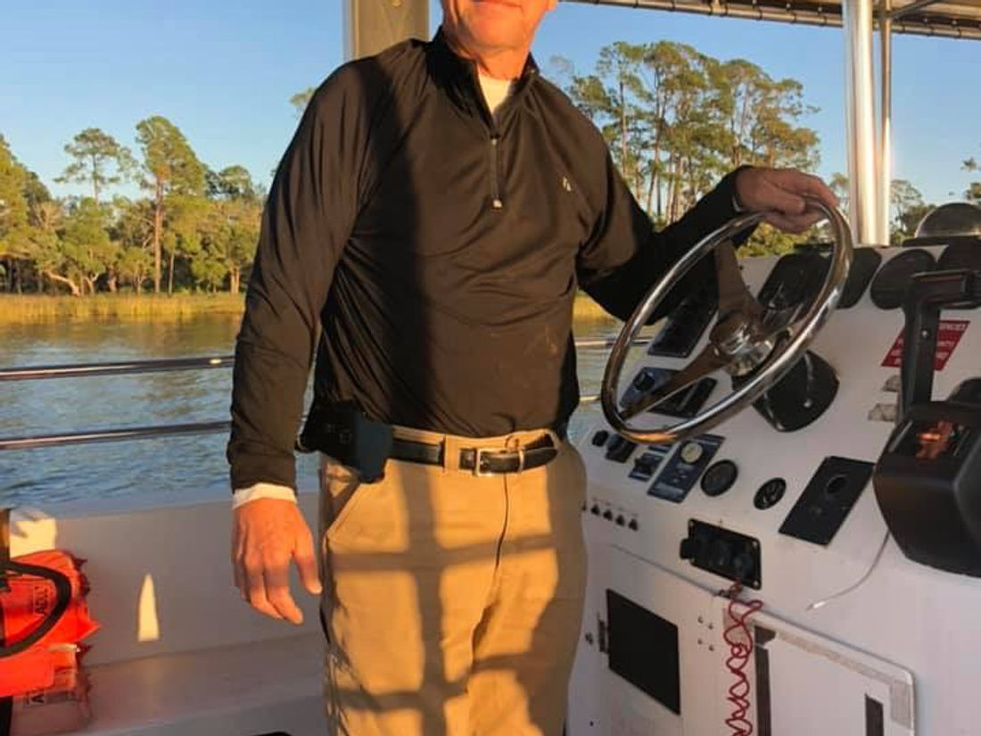 The captain at the wheel of the tour boat in golden evening light