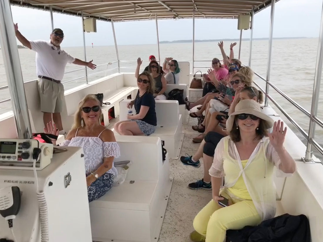 A happy group of guests aboard the tour boat with the captain